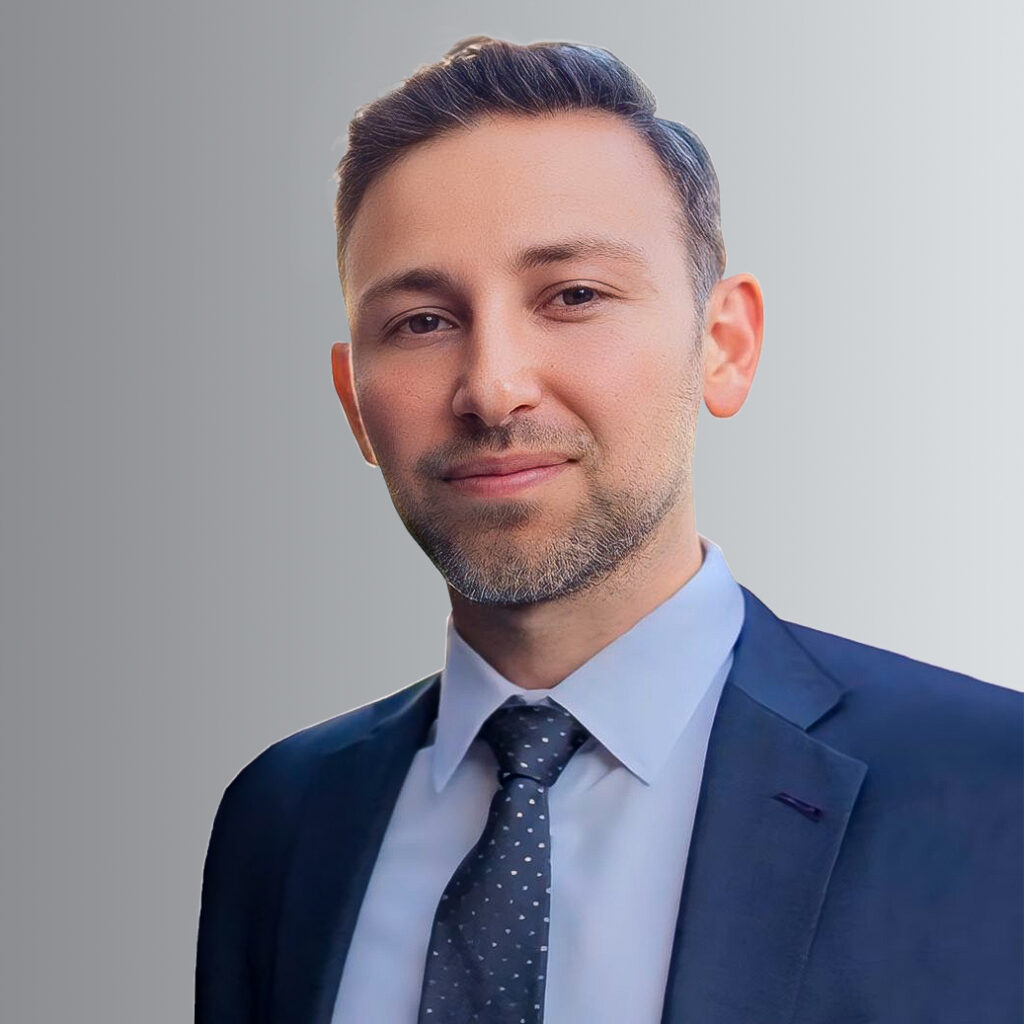 Professional man in a suit with a confident expression posing against a neutral background. Perfect for business or corporate profile images and professional portraits.